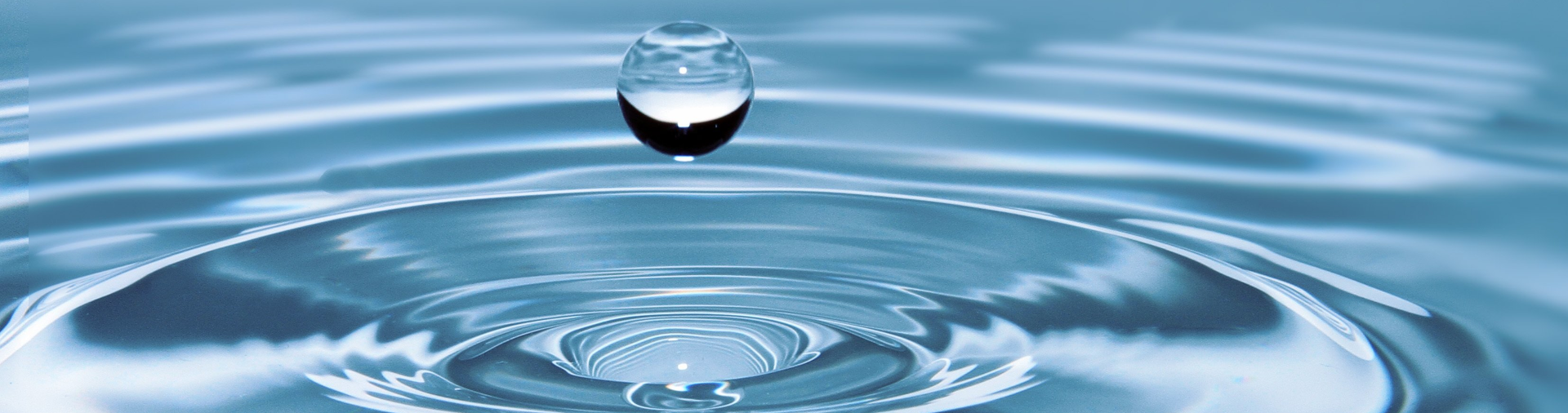 Wassertropfen fällt auf eine Fläche und erzeugt Schwingungen