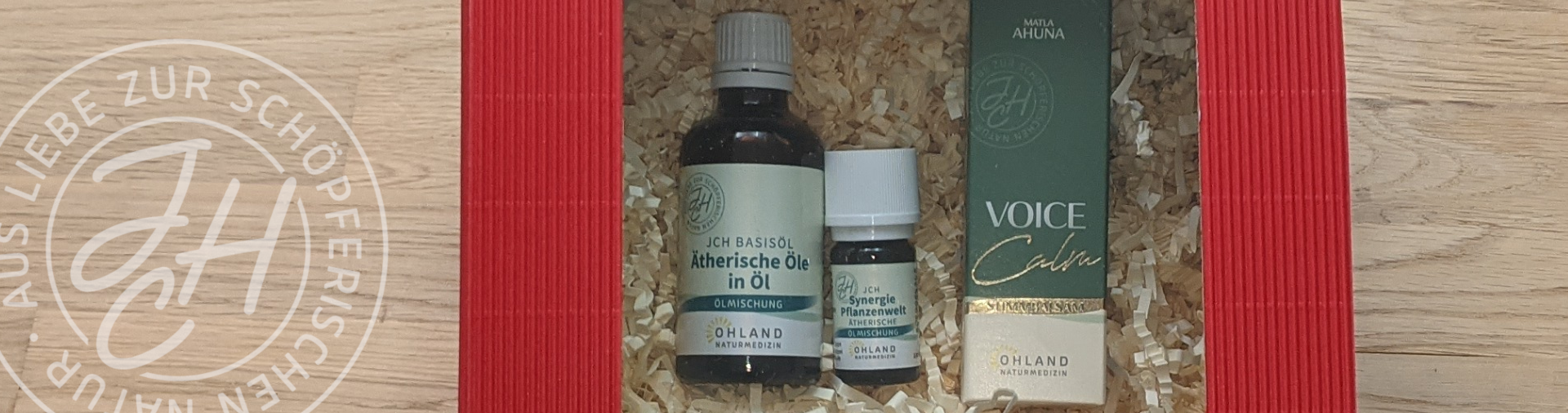 Rote Geschenkbox mit Fenster und Dekopapier auf dem 3 Produkte Liegen